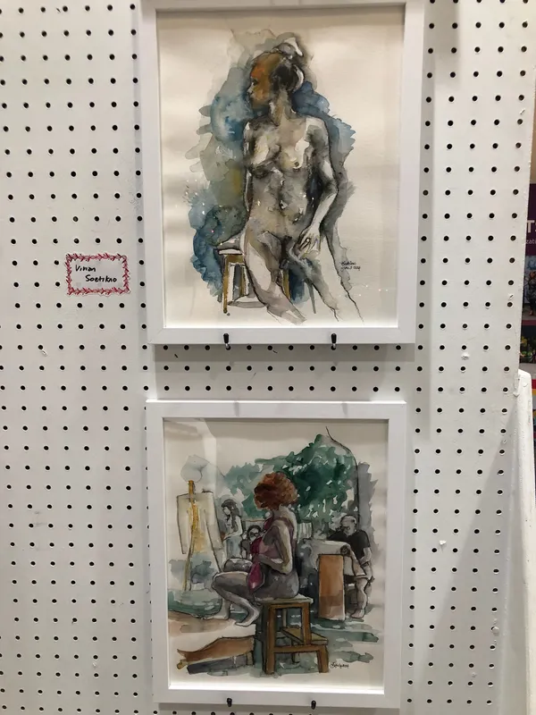 Two framed watercolours: a seated nude, and a clothed model posing on a stool outdoors among artists.